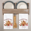 Detail of Christmas gingerbread house printed white tea towels on a wooden kitchen rack - White Gingerbread Bakery Pattern