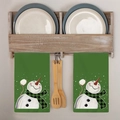 Dettaglio di due strofinacci natalizi verdi con pupazzo di neve su un portasciugamani in legno - Pupazzo di Neve Plaid (MJBT96-4)