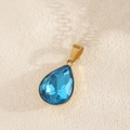 Detail van een waterdruppel blauwe kristallen hanger met gepolijste vergulde edelstalen zetting - Meerblauw