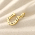 Macro shot of gold-plated horseshoe pendant with inlaid sparkling cubic zirconia stones - Gold Plated White Zirconia Horseshoe (NAK10-4)