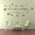Close-up of champagne gold acrylic butterfly wall decals with 'her vibe is pretty' text - Brown