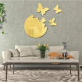 Pegatinas de pared de espejo de mariposa dorada en una pared de sala gris con textura moderna - Dorado