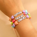 Primer plano de tres pulseras elásticas K-pop con cuentas y letras RUMI ZOEY MIRA - Combinación Multicolor de Corazón Mate