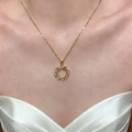 Elegant gold olive leaf wreath necklace with zircon stones worn by a model in a dress - Gold (8381)