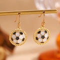 Makro-Detail von goldenen Fußball-Ohrhängern mit schwarz-weißer Emaille-Oberfläche - Fußball Ohrringe (11482)