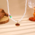 Vue détaillée du collier de perles avec perles colorées et pendentif de rugby doré - Collier Rugby (11356)