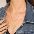 Gold-plated sunburst pendant necklace with hollow radial design on a model wearing denim - Gold Round Radiant Necklace (WG-1005)
