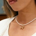 Elegant pearl necklace with golden balloon dog pendant on model's neckline - Gold Balloon Dog Pearl Chain (04 kc Gold K-244)