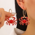 Golden hoop earrings with vibrant red enamel crab pendants in a bold beach style - Red Crab Earrings (12373)