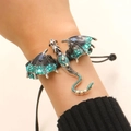 Detail of hand-woven bracelet featuring a vintage enamel dragon with blue crystals - Woven Bracelet (H-105) / Sky Blue