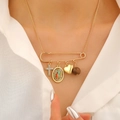Detail of gold safety pin necklace with heart, cross, and religious icon pendants - Religious Medal Necklace (0142) / KC Gold