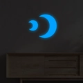 Adesivi murali luna blu luminosa con effetto fluorescente su una parete scura materica - Stile Doppia Luna / Blu