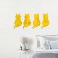 Detailansicht von vier gelben Acryl-Katzen-Spiegelwandaufklebern an einer weißen Wand - Gold