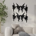 Detail view of 8 black 3D fairy acrylic wall stickers displayed above a gray fabric sofa - Black