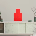 Detail of red square acrylic mirror wall stickers showing clear reflection on living room wall - Red