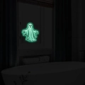 Glow in the dark ghost wall decal in a dark bathroom for Halloween party decorations - Fluorescent Green