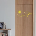 Dettaglio di adesivi murali a specchio in acrilico con luna e stelle su porta di legno - Oro