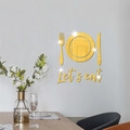 Detailed view of gold mirror acrylic 'Let's eat' wall art stickers in a modern dining room - Gold