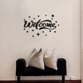 Dettaglio dell'adesivo murale Welcome in acrilico nero con stelle su parete bianca - Nero
