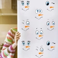 Detail showing various snowman facial expression stickers applied to a white refrigerator - DIY Snowman Face (PH_QTX45)