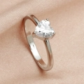 Macro shot of polished silver ring featuring a clear heart-shaped zircon on pink satin - Silver White Rhinestone