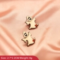 Close-up of white ghost earrings with red heart detail on pink satin background - Cute Ghost Shape