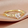 Elegant gold infinity ring with a heart-shaped zircon on a premium silk background - Light Gold White Stone