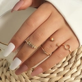 Set of four gold minimalist rings featuring heart leaf and V-shape designs on female hand - 4-Piece Set (A-297) / Four-Piece Set / KC Gold