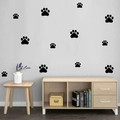 Detailansicht von 12 schwarzen Pfotenabdruck-Wandstickern auf weißer Schlafzimmerwand - Schwarz