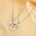 Detailed macro view of interlocking heart pendants with hand gestures and letter engraving - Hand Gesture Heart Puzzle Style (11134)