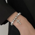 Detail of beaded pearl bracelet with a silver rhinestone cross charm on a model - Silver Bracelet (0313)
