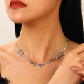 Collana d'argento con tre motivi a farfalla indossata sul collo in un primo piano dettagliato - Collana a catena serpente con fiocco argento (N-1044)
