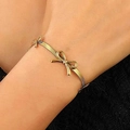 Dettaglio del ciondolo a farfalla dorato su un braccialetto sottile a maglia snake - Bracciale Intrecciato Fiocco Oro (N-1045)