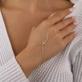 Golden hand chain bracelet with a cross pendant set with white zircon stones on model - Rhinestone Cross Ring-Linked Bracelet / Gold Style (K-555)