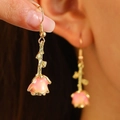 Vintage pink rose earrings with golden stem and leaf design on female model - Rose Flower Ear Hook (WG-0346) / Pink