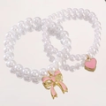 Baroque style pearl bracelet set with pink heart and bow charms on pink background - Pink Butterfly & Heart Two-Piece Set (2623) / Pink