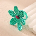 Macro view showing the metallic green flower petals and pink center of the statement ring - Green Ring