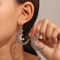 Close-up of bohemian silver crescent moon earrings with hollow filigree and star charms - Antique Silver (7486)