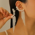 Close-up of silver tassel ear cuff with drop-shaped zircons on a model's ear - White K Long Tassel Style (9086)