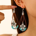 Detail of bohemian drop earring with turquoise beads and silver flower on model - Flower Leather Rope Style (1549) / Silver Green