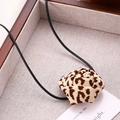 Detailed close-up of a leopard print satin rose choker with long black neck ties - Fabric Rose Tie Style / Brown White Leopard