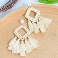 Detailed macro view of bohemian woven raffia earrings with cream white tassels and sunflower style - Beige Hollow Rhombus Tassel Style (DZ-167)