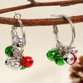 Detailed shot of Christmas bell hoop earrings with red and green charms on a wooden branch - Red and Green Small Bell Hoop Earrings (WG-0213)