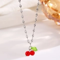 Detailed view of silver cherry pendant necklace with red translucent beads and green leaf - Silver Cherry (0061)