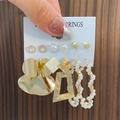 Détail du lot de boucles d'oreilles géométriques dorées et perles sur fond en bois sombre - 15 KC Or 8838