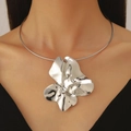 Close-up of a bold silver flower petal pendant on a rigid circular metallic choker - Necklace (02 White K 6366) / Silver Pleated Bracelet