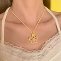 Süße gelbe Blumenkette mit rosa Perle auf Model für einen trendigen Sommer-Look - Gelb (Blume)