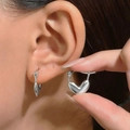 Detailed close-up of polished silver heart earrings with textured metallic finish on a model - Three-Dimensional Heart (K-902)