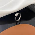 Vintage silver snake ring with scale textures and black stone eyes on reflective surface - Antique Silver
