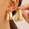 Modern minimalist gold geometric twisted hoop earrings with a polished metallic finish - Interlocking Double Ring Style / KC Gold